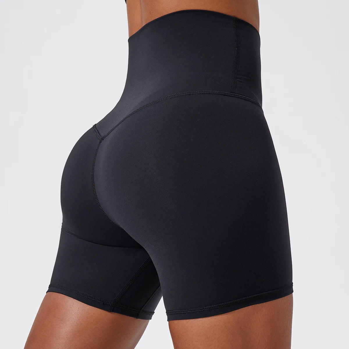 Back view of model wearing black women’s high-waist cycling shorts – super soft tummy control biker workout shorts