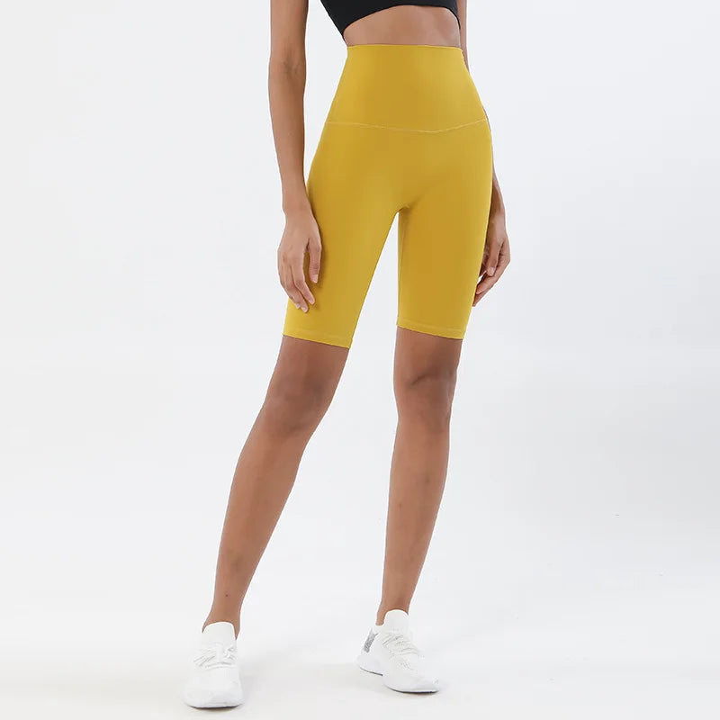 Model wearing yellow women’s breathable high-waist cycling shorts, tummy control biker shorts